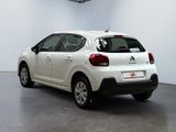 the rear of a white car is parked in a room