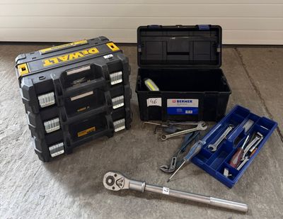 des outils posés par terre à côté d'une boîte à outils