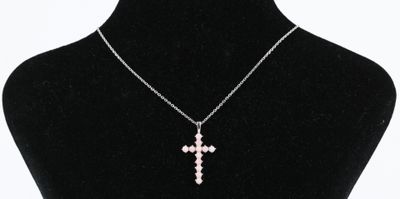 un collier avec un pendentif en forme de croix autour du cou d'un mannequin