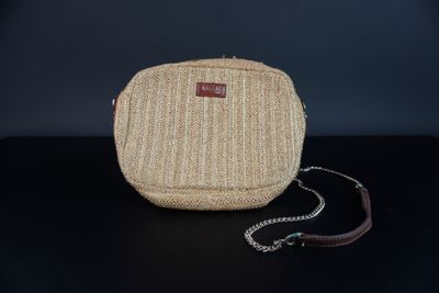 un gros plan d'un sac à main posé sur une table, entouré d'une chaîne