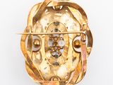 an image of a gold broochle on a white background