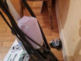 a black corded vacuum on the floor next to a wooden table