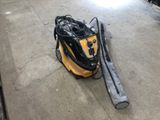 a yellow and black vacuum on the ground in a garage