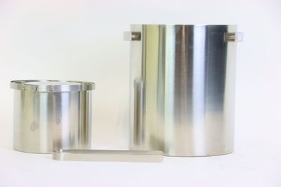 deux récipients métalliques posés l'un à côté de l'autre sur une surface blanche
