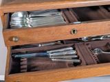 a wooden drawer with silverware in it on a table