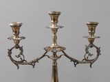 three silver candlesticks on a table next to each other