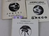 trois livres sont posés sur une table recouverte d'une nappe blanche
