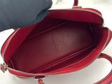 a person holding a red purse on a white surface