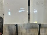 deux tableaux blancs posés sur un support à côté d'une chaise