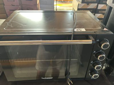 un four noir posé sur une table dans une pièce