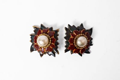 paire de boucles d'oreilles rouges et dorées ornées de perles sur fond blanc