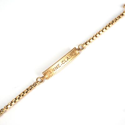 une photo d'un bracelet en chaîne d'or sur lequel est gravé un prénom