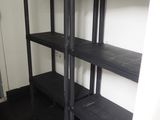 une étagère noire dans un coin de la pièce