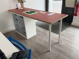 un bureau dans un coin d'une pièce, avec une chaise bleue devant
