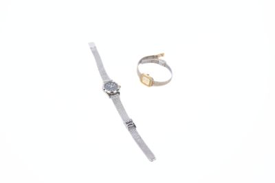deux bagues et une montre posées sur une surface blanche