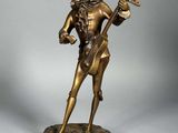 statue en bronze représentant un homme avec une guitare, posée sur un socle