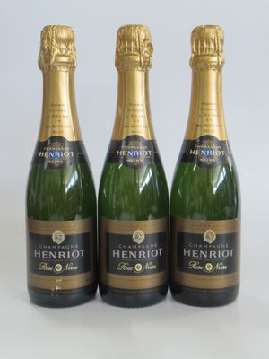 trois bouteilles de champagne posées sur une table blanche