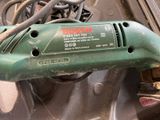 a close up of a green electric tool on a table