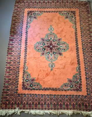 an orange rug with a cross design on it