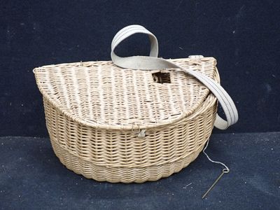un panier en osier muni d'une anse, posé sur un fond bleu
