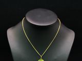 un collier avec un pendentif vert et jaune sur un mannequin