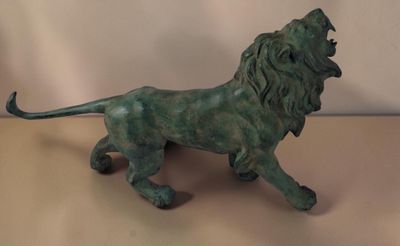 statue d'un lion posée sur une table, sur fond blanc