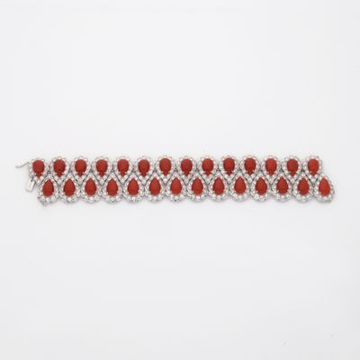 un gros plan d'un bracelet rouge et blanc posé sur une surface blanche