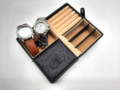 deux montres et un coffret à montres posés sur une table blanche