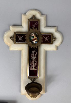 une croix accrochée au mur avec un bougeoir