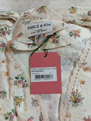 une photo d'une chemise blanche avec une étiquette rose dessus