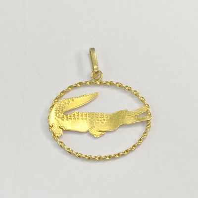 un pendentif en forme d'alligator plaqué or, entouré d'une chaîne