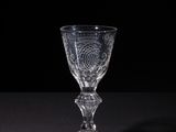 an empty wine glass sitting on a table with a black background