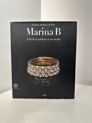 le livre est posé sur une table blanche, sur fond noir