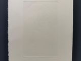 une feuille de papier blanche accrochée à un mur noir