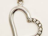 a close up of a diamond heart pendant on a white background