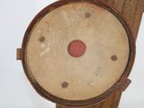 an old wooden clock with a red dot on it