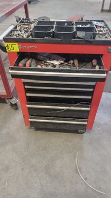 un établi rouge sur lequel sont posés des outils, dans un garage