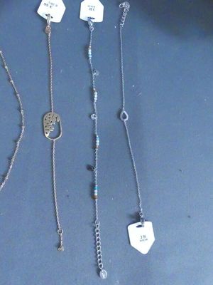 several different necklaces and bracelets are displayed on a table