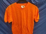 un t-shirt orange suspendu à un drap bleu devant un drap bleu