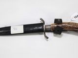 un couteau avec un manche en bois sur une surface blanche