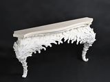 a white console table on a black background with a black backdrop