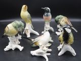 six figurines d'oiseaux posées les unes sur les autres sur une surface noire