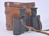 an old pair of binoculars sitting on top of a brown bag