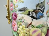 a vase with a bird and flowers on it