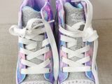 purple and white high top sneakers with silver studs on them