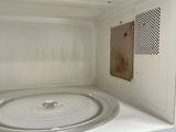 a white microwave with a dirty door on the inside of it