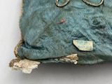 a small piece of fabric with a pair of scissors on it