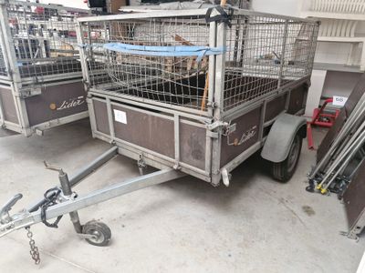 une petite remorque équipée d'une cage à l'arrière