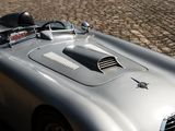 a silver sports car parked on a cobblestone street