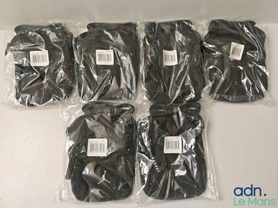 six paires de gants noirs sont emballées dans des sacs en plastique, posées sur une surface blanche